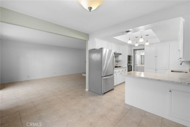 kitchen featuring visible vents, a sink, freestanding refrigerator, and white cabinetry