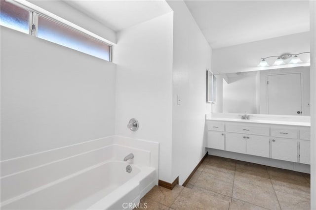 full bathroom with tile patterned floors, vanity, baseboards, and a washtub