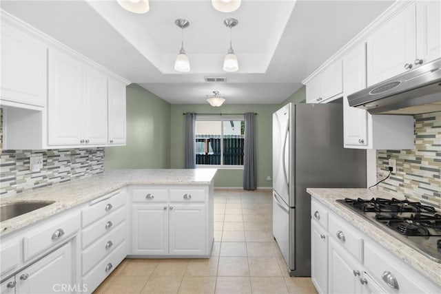 kitchen featuring a tray ceiling, white cabinetry, visible vents, under cabinet range hood, and stainless steel appliances