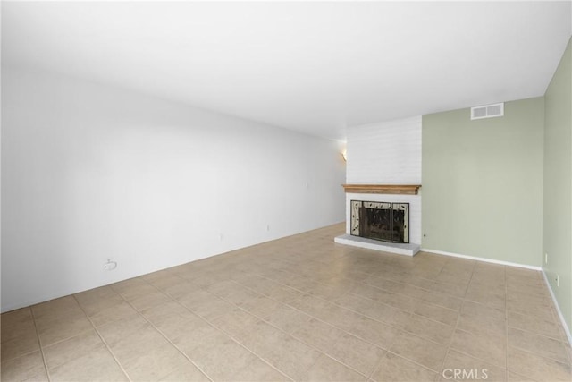 unfurnished living room with light tile patterned flooring, a fireplace, and visible vents