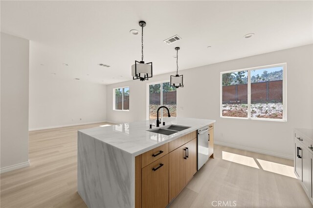 5978 Copperfield Ave, Riverside, CA 92506 - kitchen featuring a sink, dishwasher, light wood-style floors, a kitchen island with sink, and light stone counters