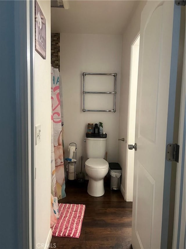 full bathroom with wood finished floors, curtained shower, and toilet