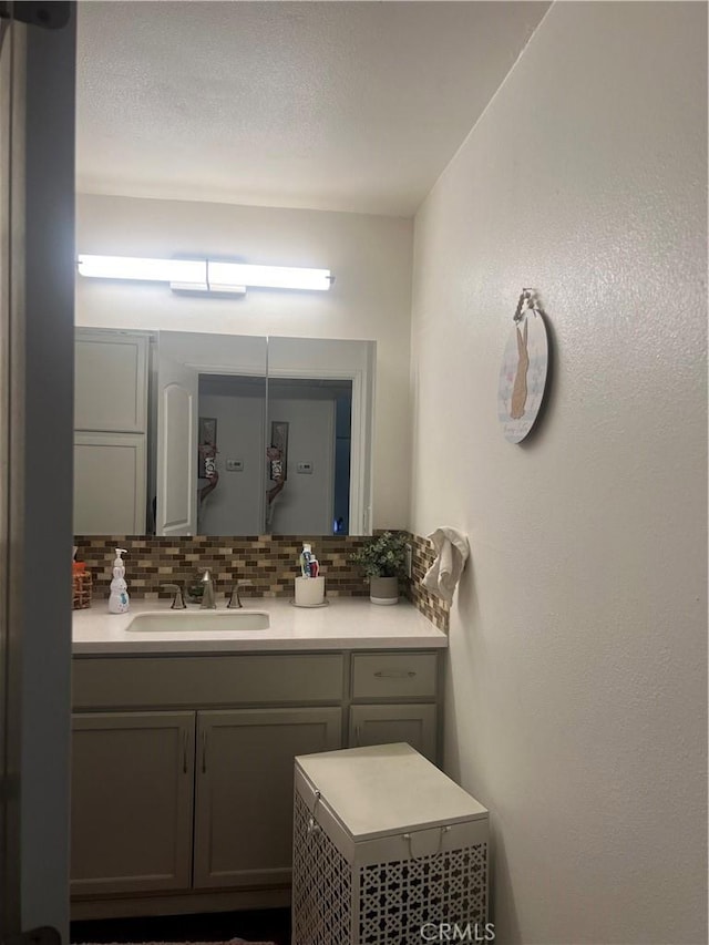 bathroom with tasteful backsplash and vanity