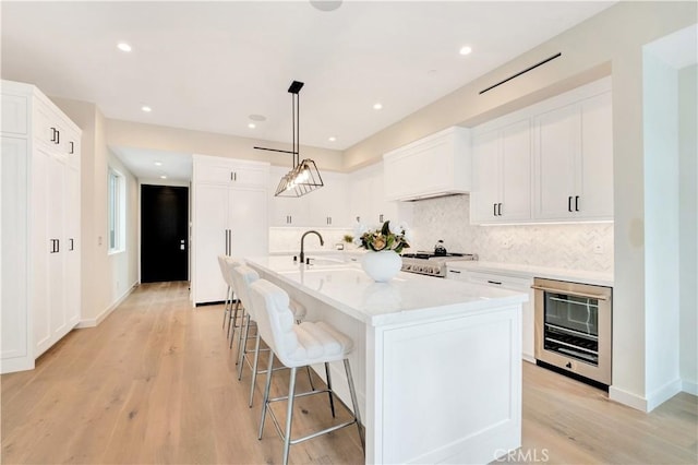 607 12th St, Huntington Beach, CA 92648 - kitchen featuring light wood-style flooring, light countertops, stove, beverage cooler, and a sink