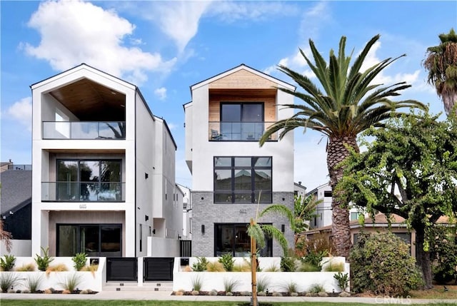 607 12th St, Huntington Beach, CA 92648 - view of front of home with stucco siding, brick siding, and a balcony
