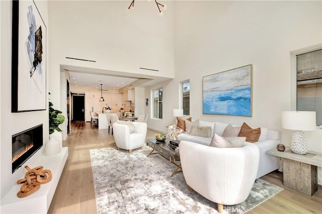 607 12th St, Huntington Beach, CA 92648 - living room with a glass covered fireplace, a towering ceiling, and light wood-style floors