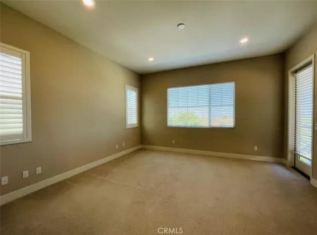 empty room featuring recessed lighting, baseboards, and a wealth of natural light