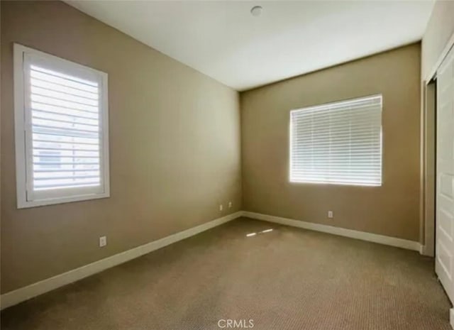 unfurnished bedroom with a closet, carpet flooring, and baseboards