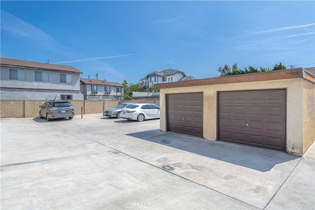 garage featuring fence and a residential view