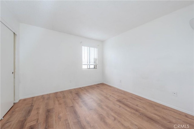 empty room featuring light wood-style floors and baseboards