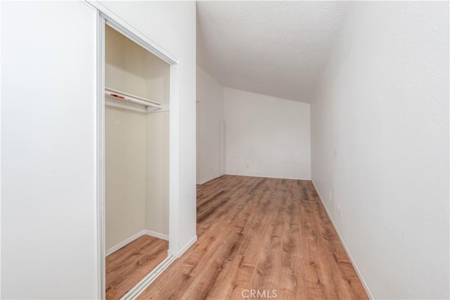 walk in closet with light wood finished floors