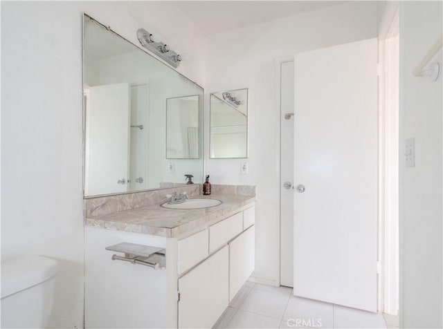 bathroom featuring toilet, tile patterned flooring, and vanity