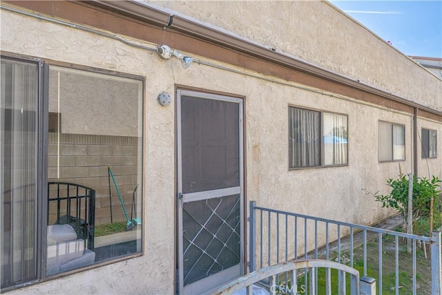 doorway to property featuring stucco siding
