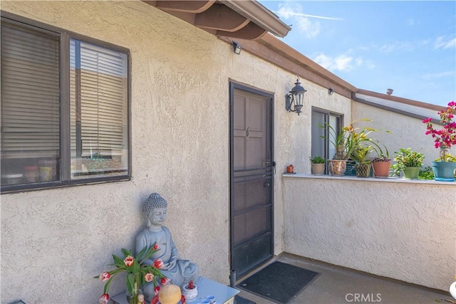 view of exterior entry featuring stucco siding