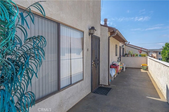 exterior space with stucco siding and a balcony