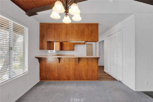 5342 Lone Pine Canyon Rd, Wrightwood, CA 92397 - kitchen featuring a notable chandelier, a peninsula, light countertops, carpet floors, and brown cabinets