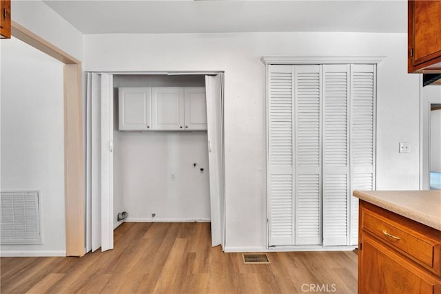5342 Lone Pine Canyon Rd, Wrightwood, CA 92397 - interior space featuring hookup for a washing machine, light wood-type flooring, visible vents, baseboards, and cabinet space