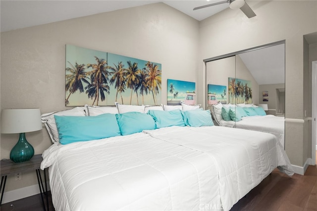 bedroom featuring lofted ceiling, baseboards, a closet, ceiling fan, and wood finished floors