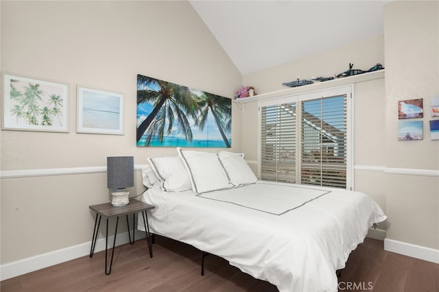 bedroom featuring baseboards, wood finished floors, and vaulted ceiling