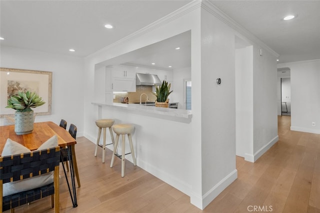 dining space featuring light wood-style flooring, baseboards, ornamental molding, and recessed lighting