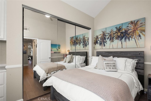 bedroom with visible vents, high vaulted ceiling, a closet, and wood finished floors