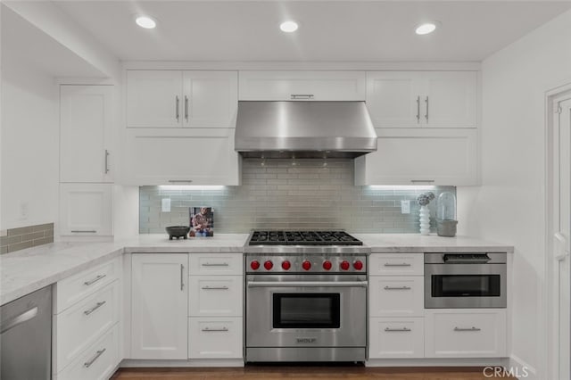 kitchen with white cabinets, ventilation hood, light stone countertops, and stainless steel appliances