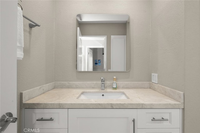 bathroom featuring a textured wall and vanity