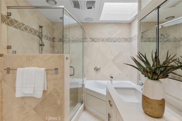 full bath with visible vents, tile walls, a shower stall, and vanity