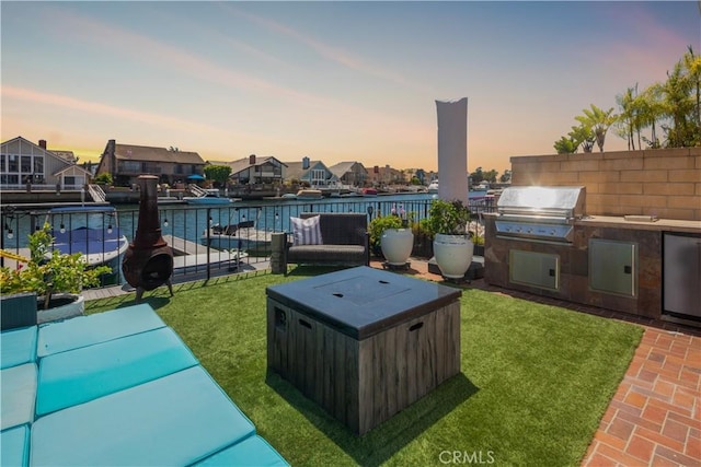 view of patio featuring fence, grilling area, and an outdoor kitchen