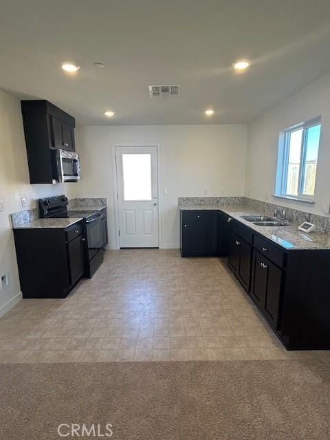 771 Brent Ct, Merced, CA 95341 - kitchen with stainless steel microwave, dark cabinets, a sink, black range with electric stovetop, and recessed lighting