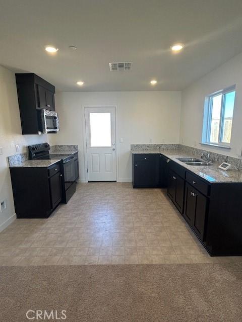 771 Brent Ct, Merced, CA 95341 - kitchen featuring stainless steel microwave, electric range, dark cabinetry, and recessed lighting
