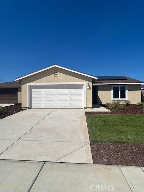 771 Brent Ct, Merced, CA 95341 - ranch-style home with stucco siding, solar panels, concrete driveway, and a front lawn
