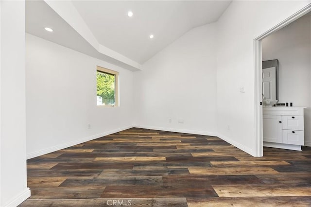 unfurnished room featuring baseboards, wood finished floors, and lofted ceiling