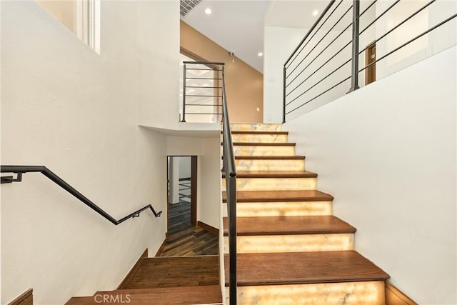staircase featuring wood finished floors, visible vents, and recessed lighting