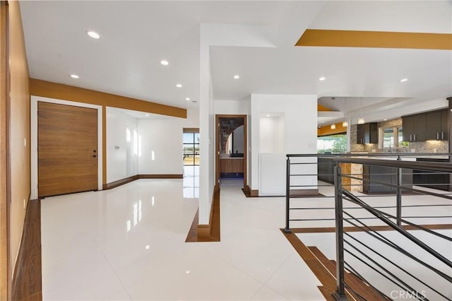 tiled entrance foyer with baseboards and recessed lighting