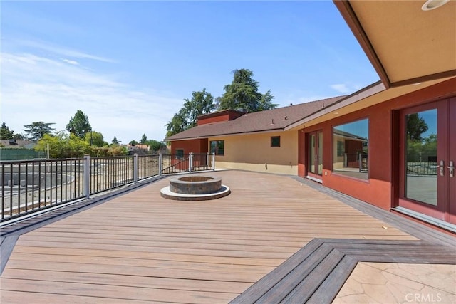 wooden deck featuring french doors and a fire pit