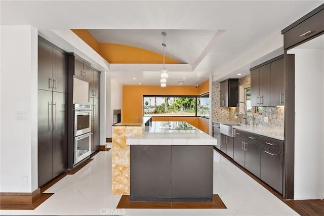 kitchen with tasteful backsplash, a kitchen island, stainless steel double oven, lofted ceiling, and a sink