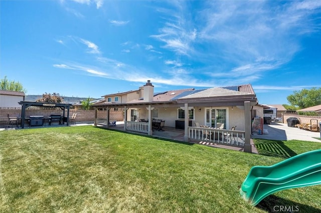 42370 61st St W, Lancaster, CA 93536 - back of property featuring a playground, a patio area, stucco siding, and a chimney