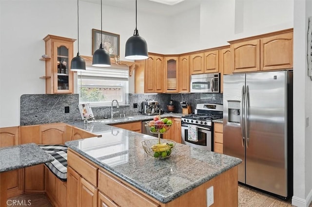 42370 61st St W, Lancaster, CA 93536 - kitchen featuring appliances with stainless steel finishes, a peninsula, stone countertops, glass insert cabinets, and decorative backsplash