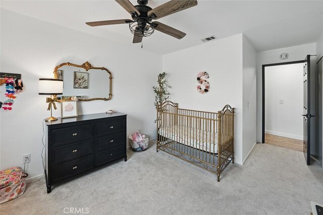 42370 61st St W, Lancaster, CA 93536 - bedroom featuring light carpet, a crib, and a ceiling fan
