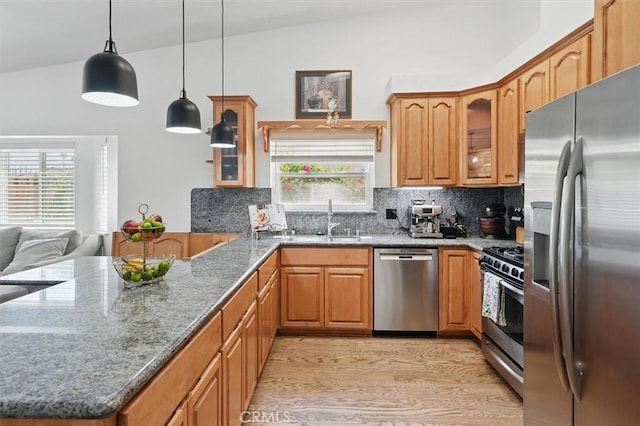 42370 61st St W, Lancaster, CA 93536 - kitchen featuring appliances with stainless steel finishes, vaulted ceiling, decorative backsplash, plenty of natural light, and glass insert cabinets
