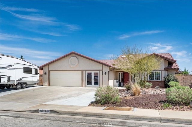 42370 61st St W, Lancaster, CA 93536 - ranch-style house with stucco siding, a tile roof, french doors, a garage, and concrete driveway