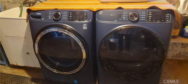 laundry area featuring tile patterned floors, laundry area, and washing machine and dryer