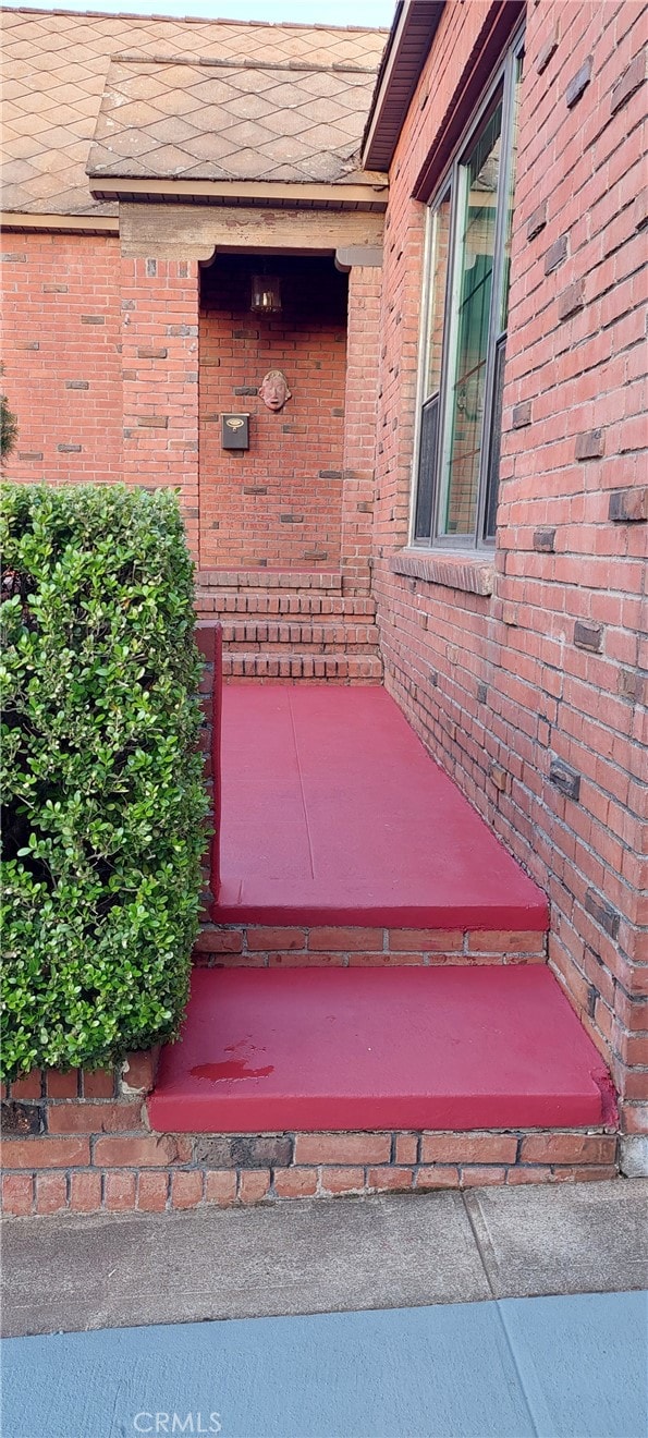 view of exterior entry featuring brick siding