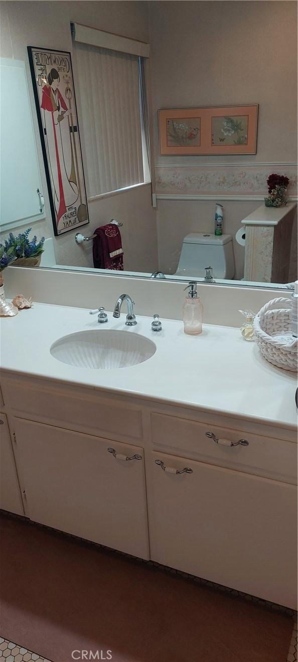 half bathroom featuring vanity and toilet