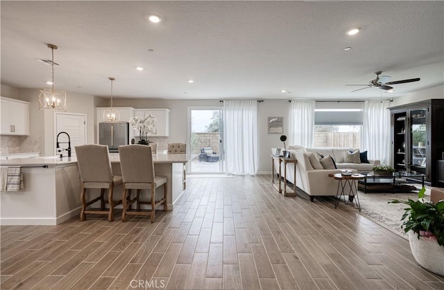 1093 Traverse Dr S, Madera, CA 93636 - living area featuring recessed lighting, light wood-style flooring, ceiling fan with notable chandelier, and baseboards