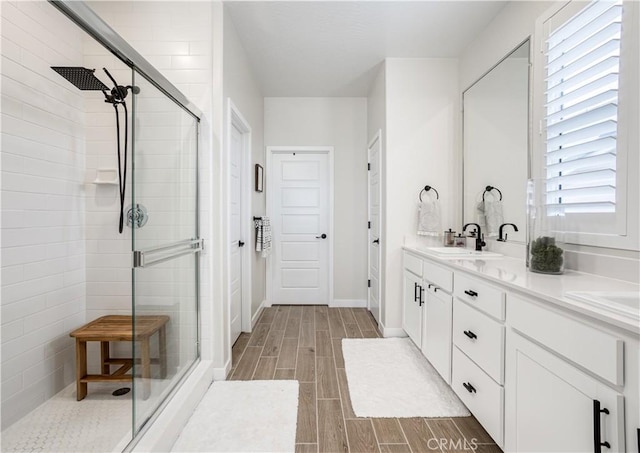 1093 Traverse Dr S, Madera, CA 93636 - bathroom with double vanity, baseboards, wood tiled floor, a sink, and a stall shower