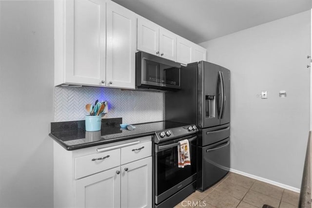 kitchen featuring stainless steel microwave, baseboards, white cabinetry, dark countertops, and decorative backsplash