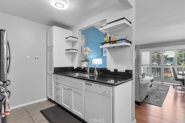 kitchen featuring freestanding refrigerator, white cabinetry, open shelves, a sink, and white dishwasher