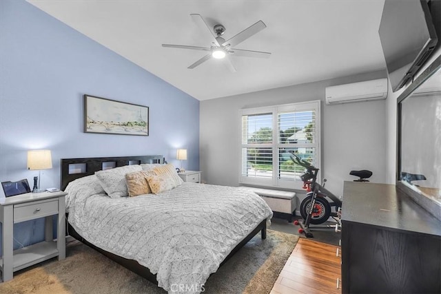 bedroom with ceiling fan, lofted ceiling, wood finished floors, and a wall unit AC